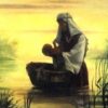 Woman holding baby by the river.